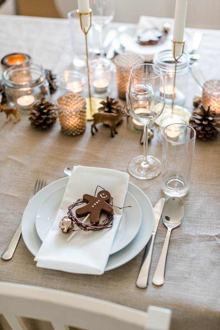 Weihnachtliche Tischdekoration mit Kerzen und Lebkuchenmann aus Schokolade